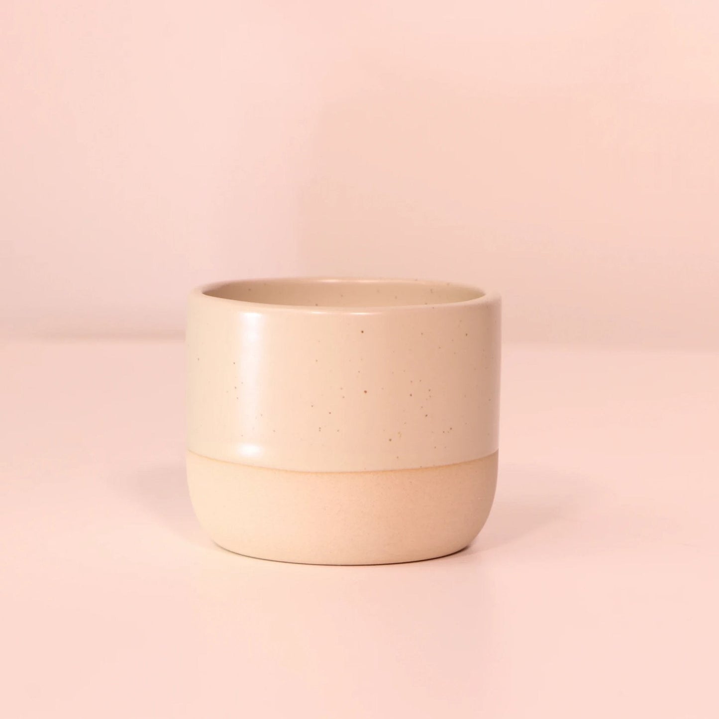 Handgemaakt keramisch matcha kopje met speckled design op zachte roze achtergrond