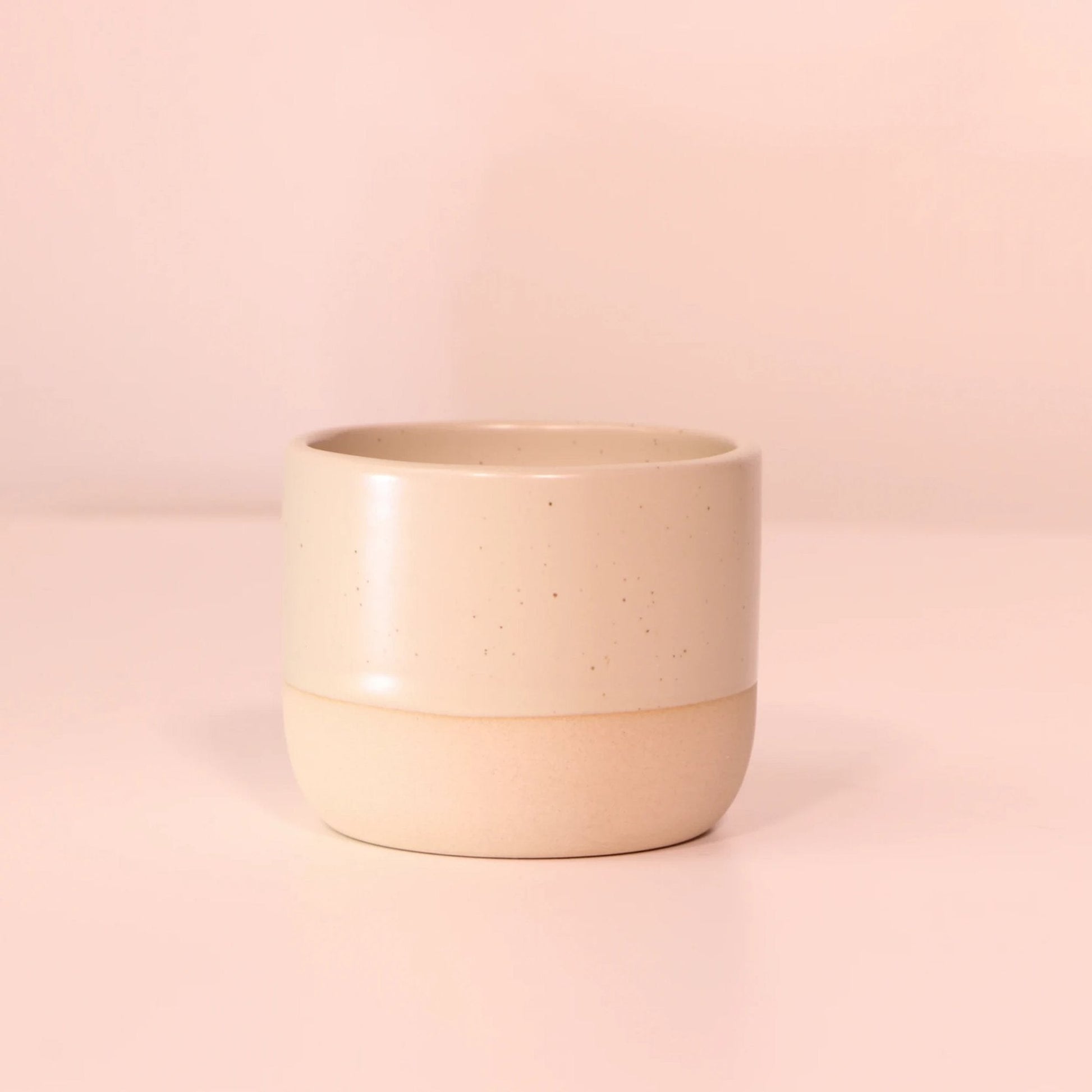 Handgemaakt keramisch matcha kopje met speckled design op zachte roze achtergrond