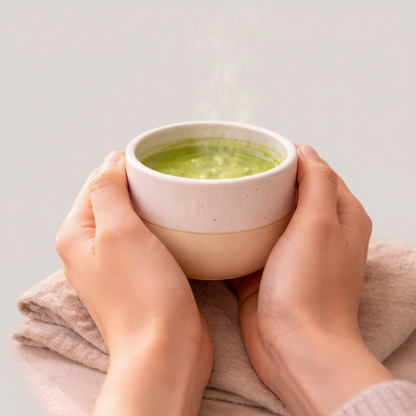 Handen die handgemaakt keramisch matcha kopje vasthouden — close-up